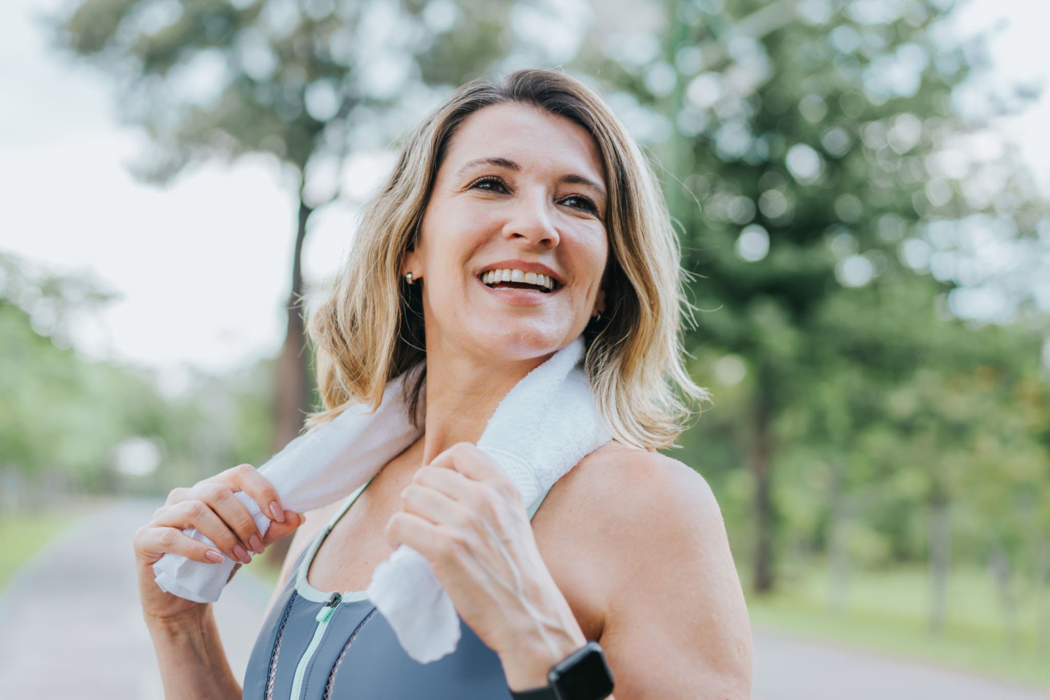 Healthy active female with towel around neck after exercising.